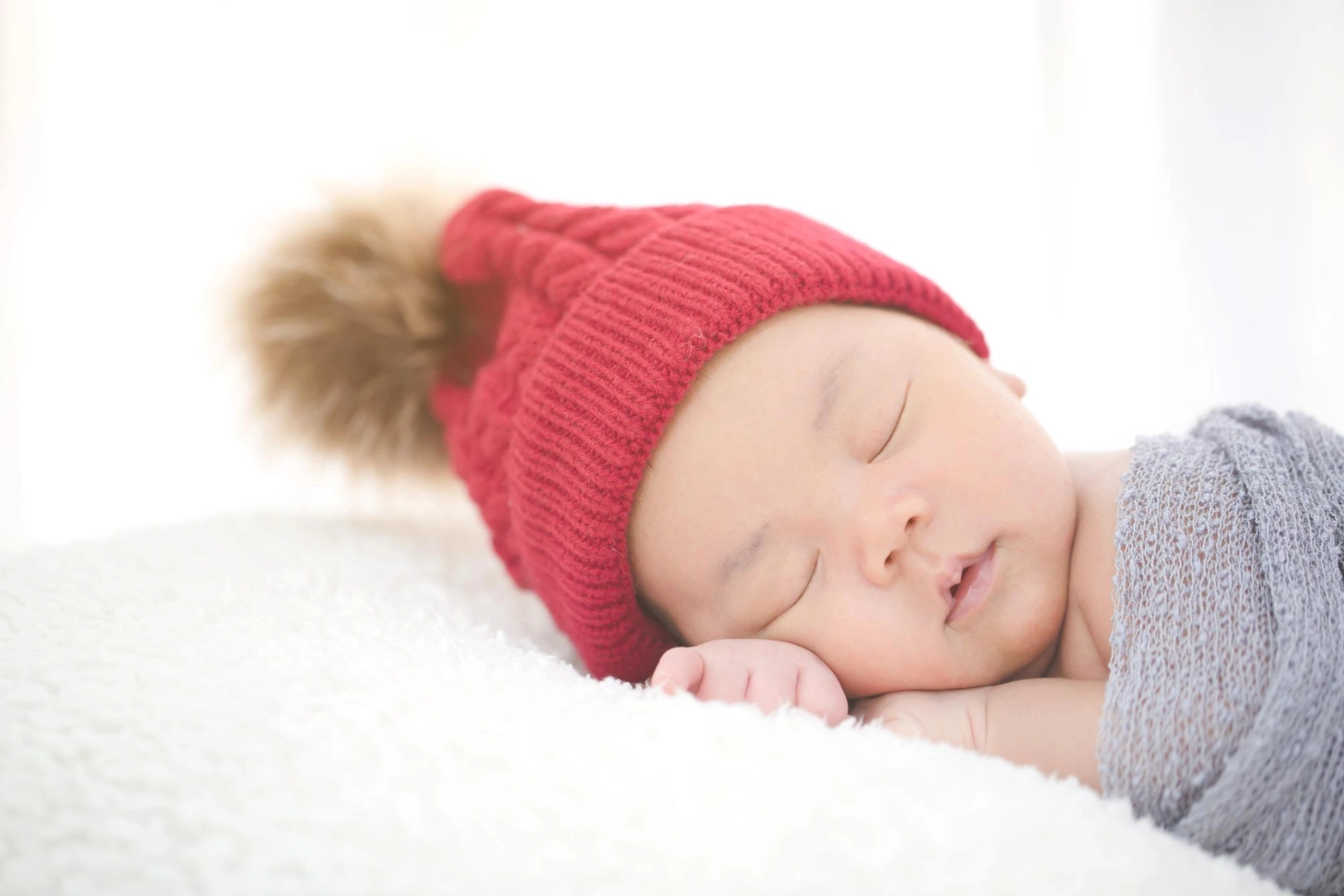 A newborn baby sleeping on the furry cloth.